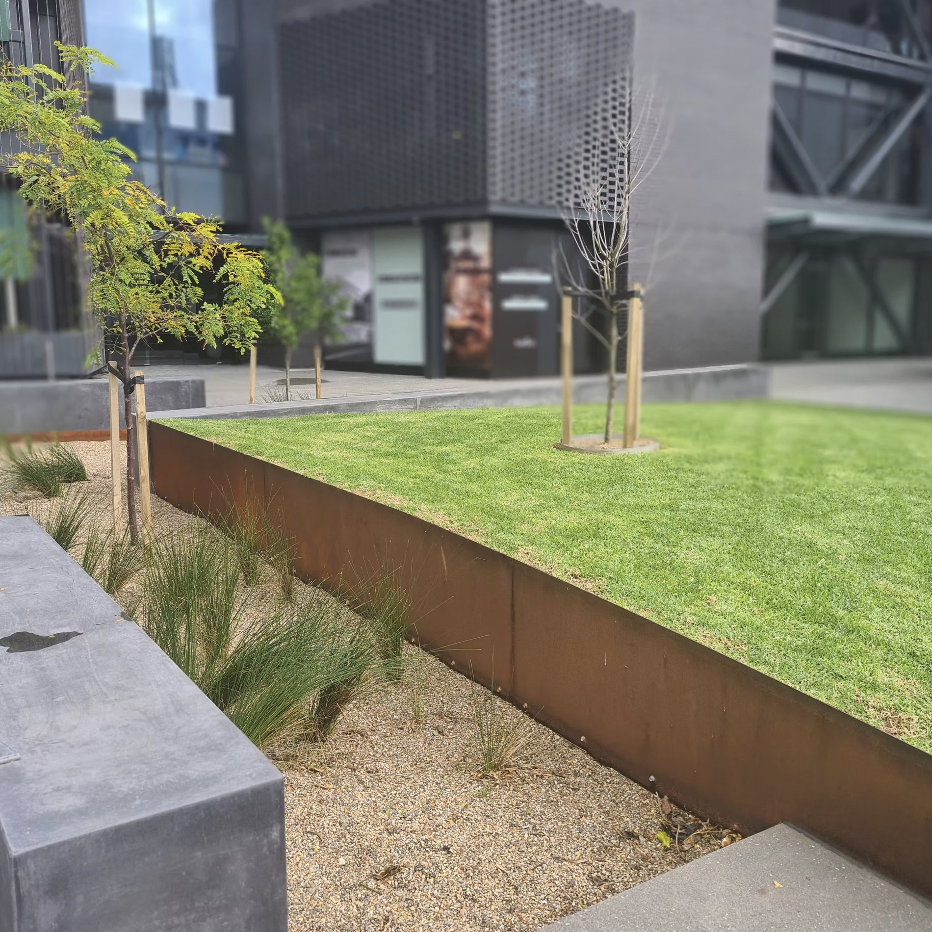A corten steel lawn edge beside a modern building